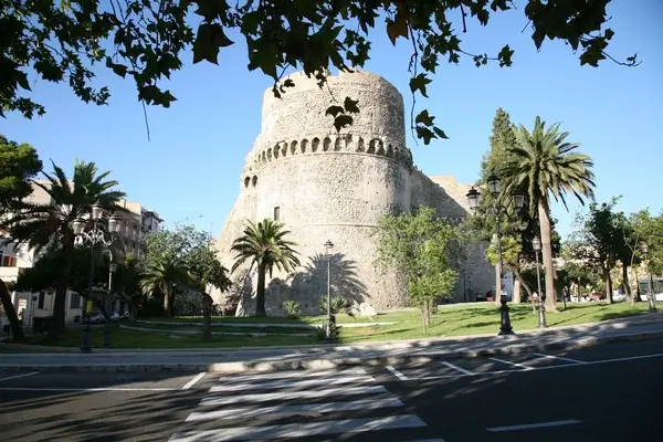 Lateral view of the Aragonese Castle of Reggio Calabria with its two cylindrical towers and stone walls rising in the historic city center.