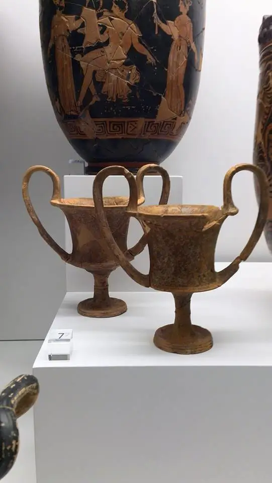 Ancient Greek kantharos wine cup displayed among the cups at the National Archaeological Museum of Reggio Calabria, symbol of Magna Graecia ritual culture.