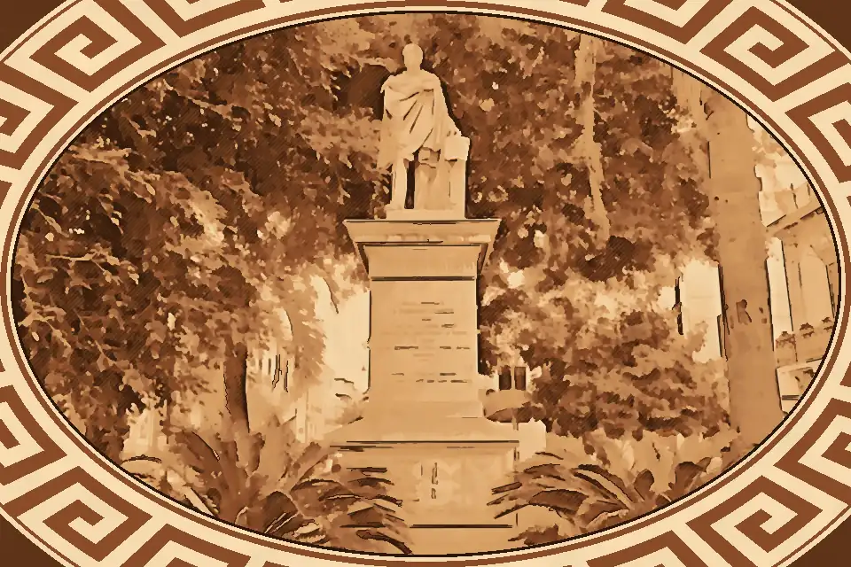 Stone statue of Federico Genoese on a tall pedestal in Piazza Federico Genoese, surrounded by lush palm trees and urban greenery in Reggio Calabria