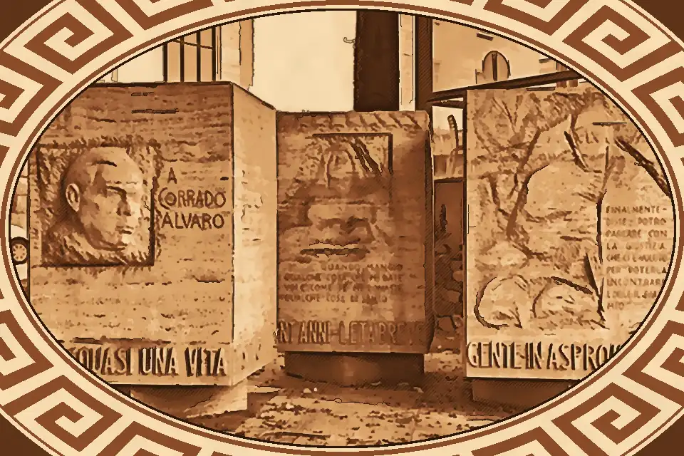 Monument to Corrado Alvaro in Reggio Calabria featuring three travertine marble cubes engraved with quotes and figures from the author’s works, located near the National Archaeological Museum of Magna Graecia.