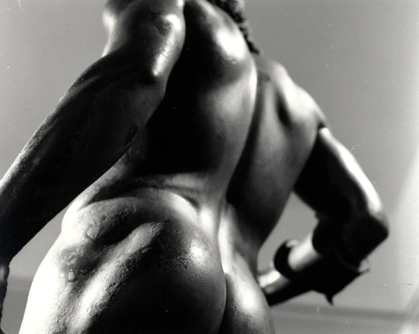 Close-up detail of the back of the Riace Bronze statue displayed at the Reggio Calabria Museum, highlighting the anatomical precision of ancient Greek sculpture.