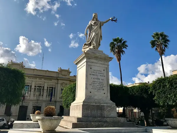 Statue of Italia Turrita holding a sword and laurel crown in Piazza Italia, Reggio Calabria.