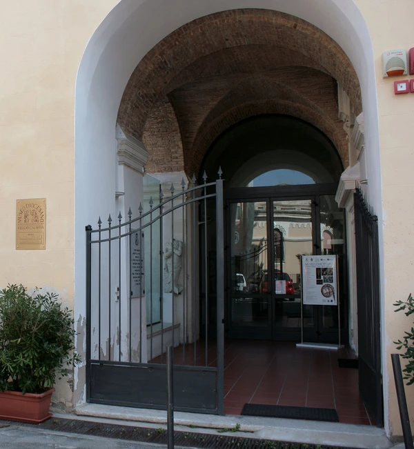 Main entrance of the Diocesan Museum of Reggio Calabria inside the Archbishop’s Palace, featuring historic arches and sacred architectural details.
