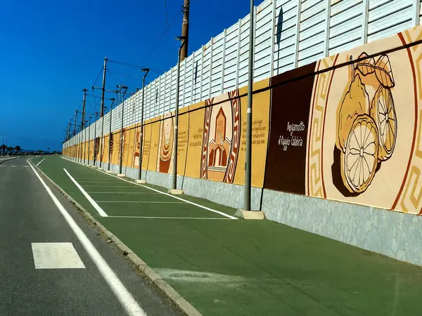 Long mural-covered promenade at Parco Lineare Sud in Reggio Calabria with cycling and jogging paths by the sea.
